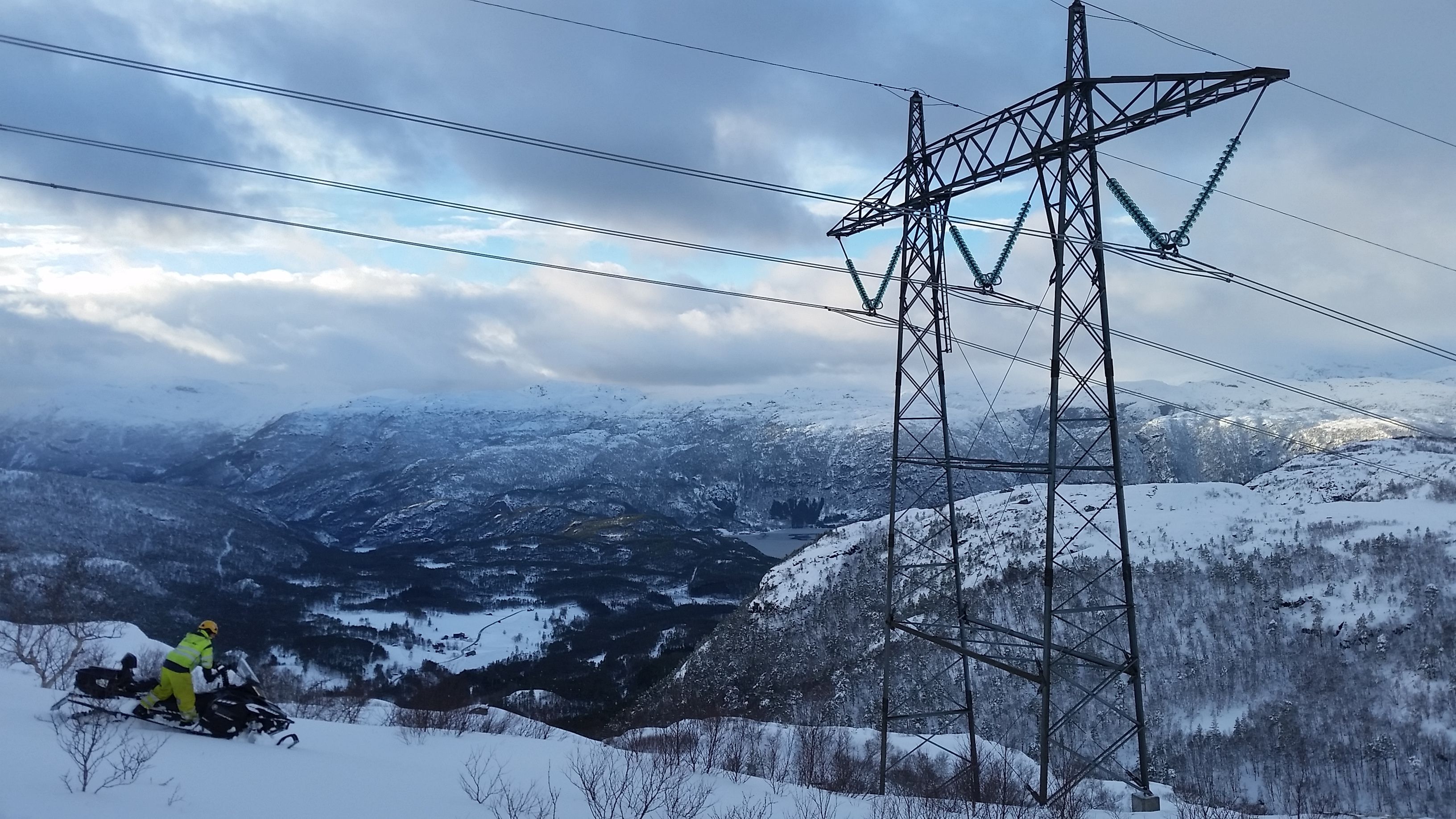 Person i verneklær på snøscooter
