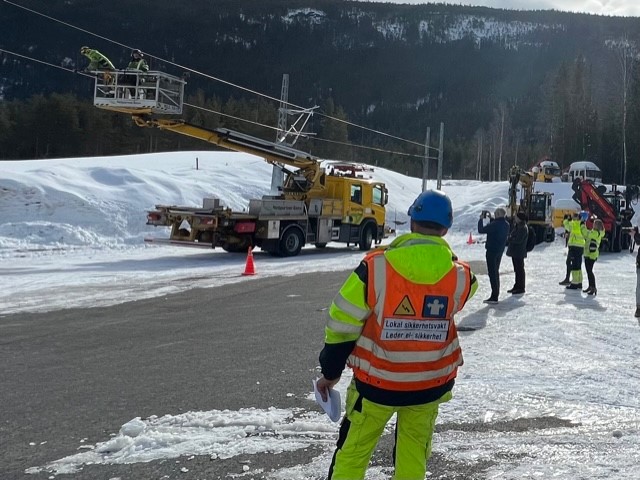 En energimontør ser på at kontaktledning kuttes av kollegaer under åpningen av Nettpartner sitt nye treningssenter på Torpo